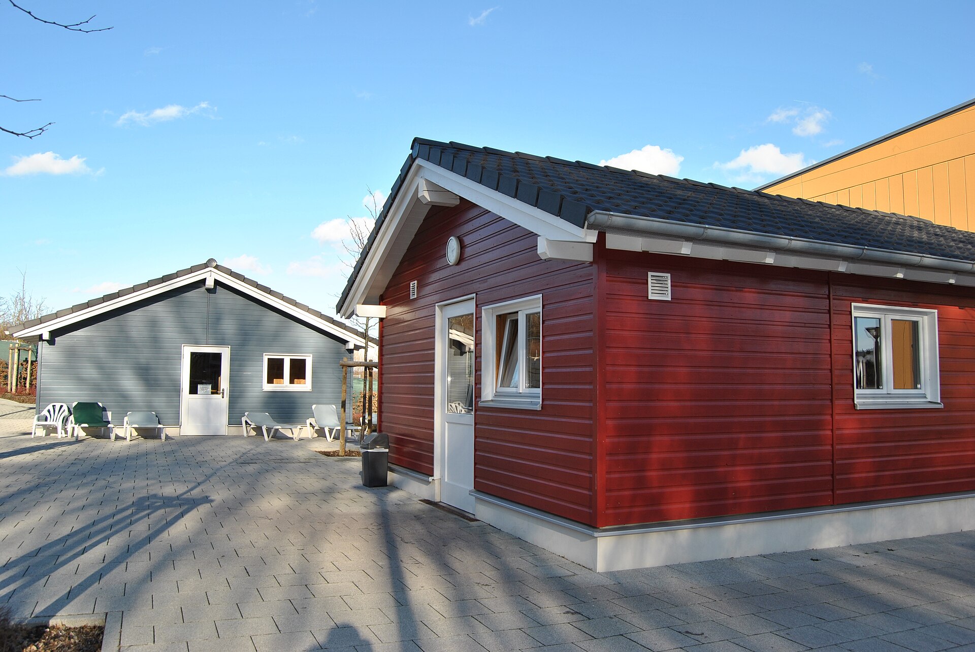 Wooden sauna cabins on a quiet street, lit by lamps